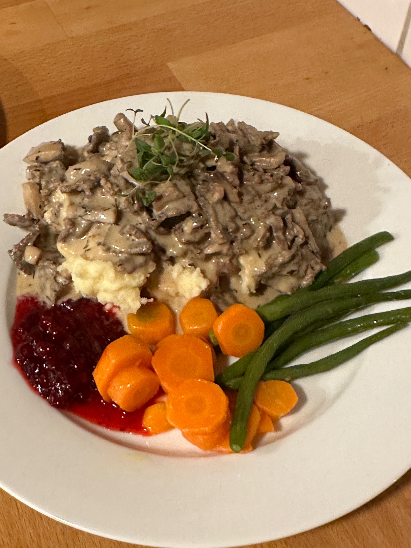 Varmrett med kremet saus, grønnsaker og tyttebær